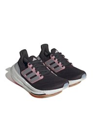 Svarta idrottsskor med en strukturerad ovandel och rosa gummiaccenter. Har en vit mellansula och en grå gummisola med genomskinliga inslag.