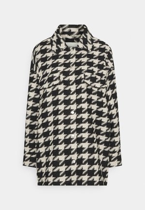 Kurtka w biało-czarny wzór w jodełkę, z kołnierzem, długimi rękawami, kieszeniami na piersi i srebrnymi guzikami, wykonana z teksturowanej tkaniny.