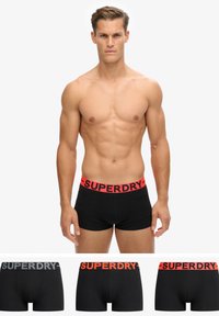 Boxers noirs avec une ceinture logo contrastante en rouge et gris, fabriqués dans un matériau en coton doux et avec un design ajusté.