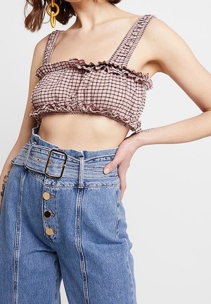 Roze gingham crop top met gerimpelde randen en brede bandjes, gecombineerd met high-waisted blauwe spijkerbroek met een brede riem en knoopaccenten.