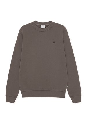 Hanorac maro cu mâneci lungi, guler rotund și tiv ribanat. Prezintă un mic logo negru "II" pe partea din față. Confecționat dintr-un material moale.