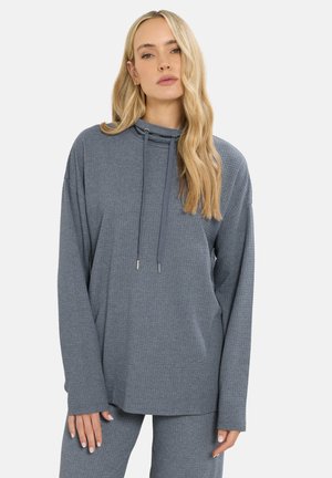 Grijze geribbelde top met lange mouwen en een hoge nek, met koordjes en een relaxed fit. Zachte stof met een textuurpatroon, gecombineerd met bijpassende broek.