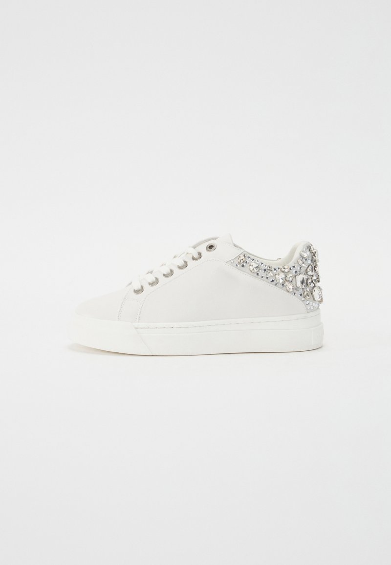 Białe sneakersy z gładkiej skórzanej cholewki, okrągłym noskiem, sznurowanym przodem i błyszczącym obcasem ozdobionym kamieniami. Płaska gumowa podeszwa.