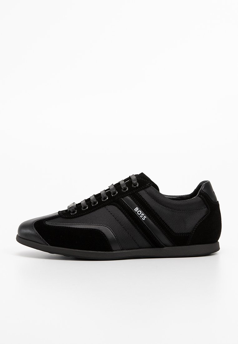 Des chaussures de sport noires alliant une combinaison de matériaux en daim et en maille, un design épuré, des accents latéraux texturés et un logo de marque.
