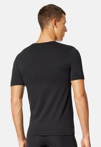 Sort kortærmet t-shirt lavet af glat bomuld, med en klassisk crew-neck og tætsiddende form, uden synlige mønstre eller accenter.