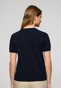 Granatowy sweter z krótkim rękawem, wykonany z miękkiej tkaniny, z okrągłym dekoltem, ściągaczami przy rękawach oraz dopasowanym pasem.