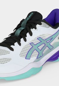 Λευκό και μωβ παπούτσι για τρέξιμο Asics με μαύρα κορδόνια, βεραμάν λογότυπο και λεπτομέρειες, καθώς και διαπνέοντα διχτυωτά πάνελ στο πάνω μέρος.