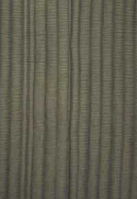Tekstūrēta auduma tumši zaļā krāsā ar vertikālu svītrainu rakstu. Materiāls ir austs ar vieglu spīdumu, radot dziļumu un vizuālu interesi.