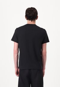 Zwarte katoenen t-shirt met een klassieke ronde hals en korte mouwen, met een gladde textuur en een eenvoudig, minimalistisch ontwerp.