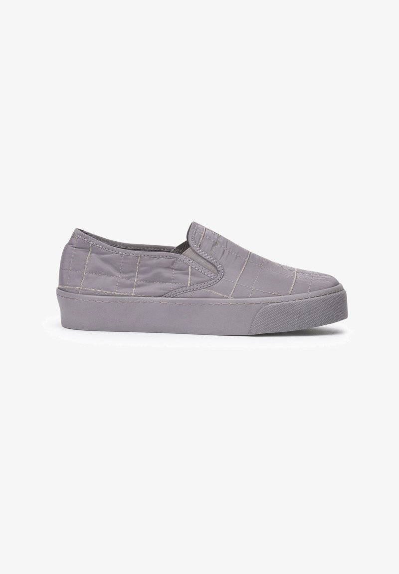 Sneaker slip-on con tomaia trapuntata grigia imbottita, inserti elastici laterali e suola in gomma spessa su sfondo bianco.