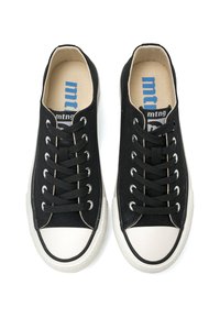 Zapatillas de lona negras con suelas de goma blanca y punteras. Presentan un diseño de cordones y una marca en azul en el interior.