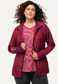 Kevyt viininpunainen takki, jossa on täysipituinen vetoketju, pitkät hihat ja peukalonreiät, kerroksittain kirkkaan vaaleanpunaisen yläosan kanssa, jossa on lehtikuviot.