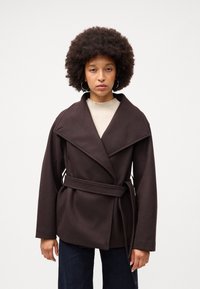 Cappotto marrone avvolgente con ampi revers, tasche laterali e vita con cintura. Realizzato in tessuto morbido con una forma strutturata e maniche lunghe.