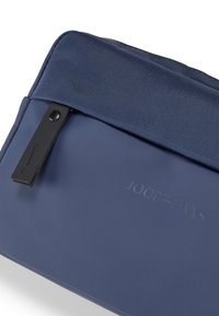 Custodia per laptop blu navy con materiale liscio, pannello in tessuto testurizzato nella parte superiore e chiusura a scatto nera con dettaglio del logo in rilievo.