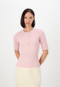 Ljust rosa ribbad trikå kortärmad topp med rund halsringning och fem knappar i guldton fram. Åtsittande siluett med texturerad tyg.