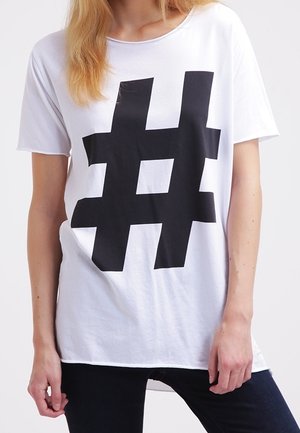 Biała bawełniana koszulka z dużym czarnym graficznym hashtagiem. Krótkie rękawy, luźny krój i okrągły dekolt.