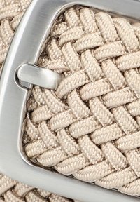 Beżowa tkanina pleciona z teksturowanym wzorem, połączona z metalową klamrą w kolorze srebrnym. Design jest skomplikowany, z ciasnym pleceniem i gładkimi krawędziami.