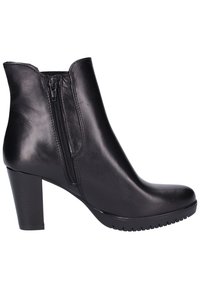 Bottine en cuir noir avec talon bloc, fermeture éclair latérale et bout arrondi, montrant le profil extérieur sur fond blanc.