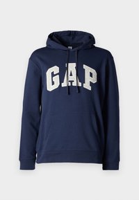 Sudadera azul marino con bolsillo tipo canguro, capucha con cordón y gran letra blanca "GAP" en el frontal en una tipografía atrevida y en bloques.