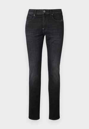 Jean en denim foncé avec une coupe slim droite, présentant un design classique à cinq poches, une fermeture à bouton et des détails de couture discrets.