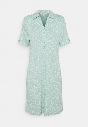 Helles grünes Hemdkleid mit weißem Blattmuster, kurzen aufgerollten Ärmeln und Kragen. Fließender Stoff mit lockerer Passform.