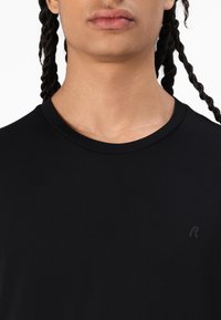 Tricou negru cu mânecă scurtă, fabricat din material neted, cu guler rotund și un logo mic, embosat, pe partea stângă.