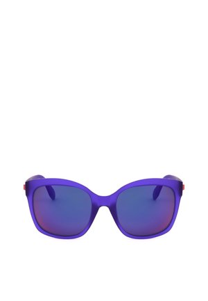 Occhiali da sole con montatura viola e grandi lenti quadrate blu, posizionati su uno sfondo bianco semplice.