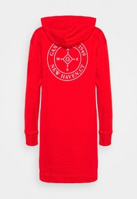 Punainen huppari-mekko pitkällä hihalla, jossa on valkoinen pyöreä graafinen kuvio takana, valmistettu pehmeästä kankaasta.