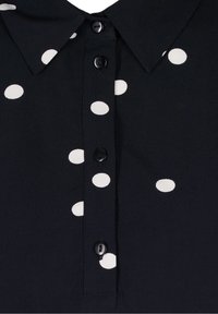 Schwarzes Hemd mit Kragen, fünf Knöpfen und einem weißen Punkten-Muster. Glattes Material mit weicher Textur.