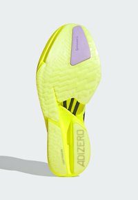 Jasnożółta podeszwa z teksturowanym wzorem, z purpurowym akcentem i logo "ADIZERO". Lekka konstrukcja zapewniająca wysoką wydajność.