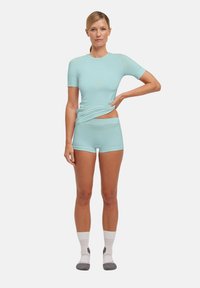 Helles blaues, kurzärmliges Oberteil und passende Shorts aus elastischem Stoff. Verfügt über ein tailliertes Design mit minimalen Nähten und Logodetail.