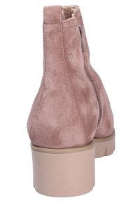 Bottine en daim rose clair avec fermeture éclair latérale, bout rond, talon bloc et doublure intérieure douce visible sur le bord supérieur.