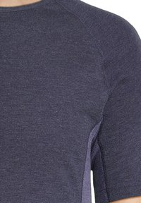 Kortærmet T-shirt i m�ørk navy stof, med en tekstureret overflade og sideslids til ekstra ventilation og bevægelse.
