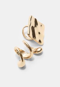 Goldfarbener Metallring mit einer texturierten, abstrakten flachen Oberfläche und spiralförmigem Design. Glatte Oberfläche mit reflektierendem Finish.