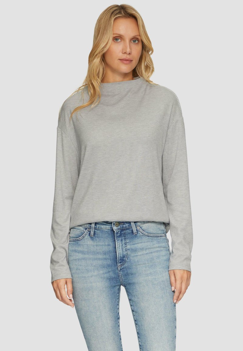 Hellegraues Langarmshirt mit hochgeschlossenem Kragen, lässiger Schnitt, glatte Textur, kombiniert mit hellblauen Jeans, lässiges Design.