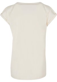 Cremefarvet kortærmet T-shirt med rund hals, glat tekstur og en afslappet pasform. Hånden er let buet i bunden.