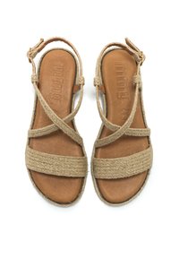 Sandali in pelle marrone con cinturini in juta intrecciata, caratterizzati da un design incrociato, suola piatta e chiusura a fibbia, su sfondo bianco.
