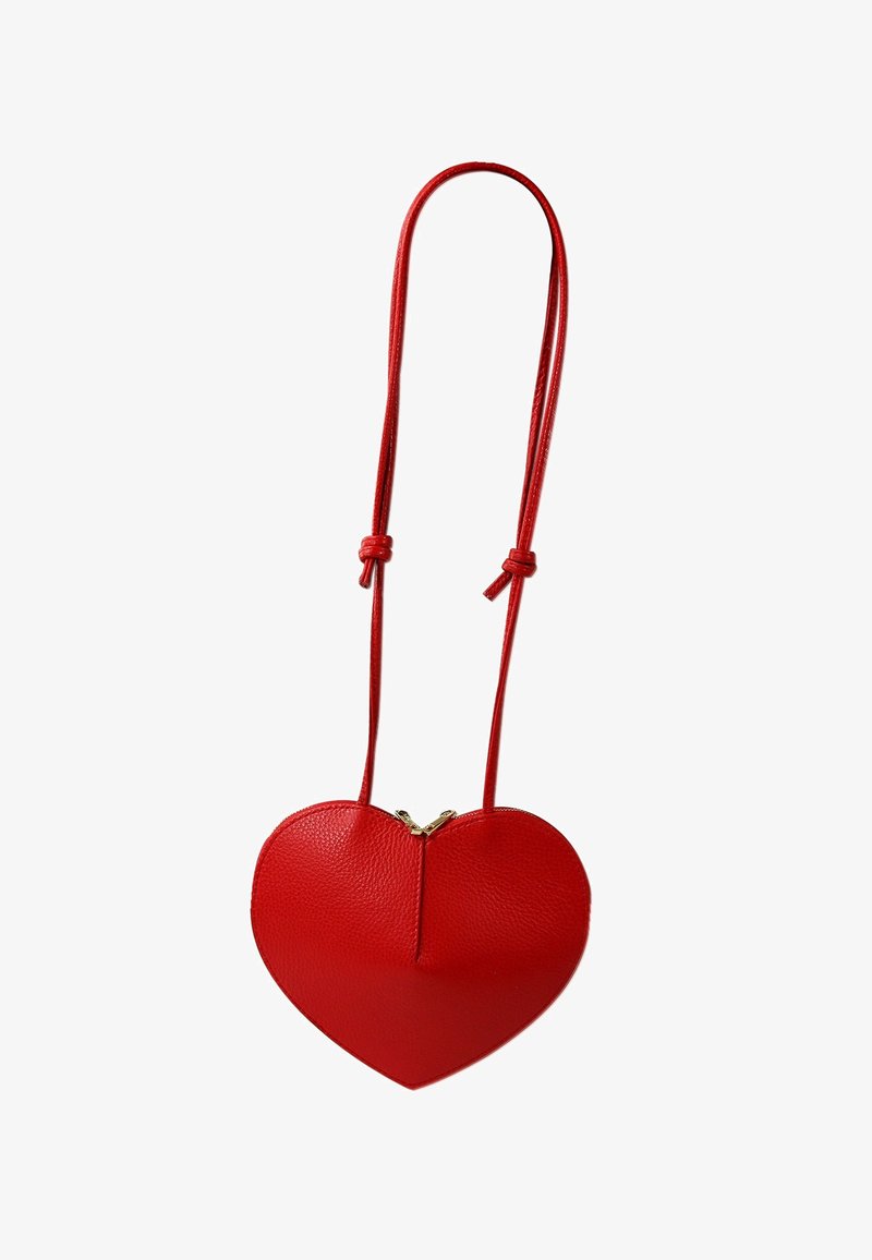 Rode leren tas in de vorm van een hart met een ritssluiting, voorzien van een lange schouderband en een gestructureerd oppervlak. Het ontwerp is symmetrisch met een gouden ritssluiting.