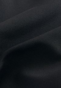 Sort stof med en glat, mat tekstur, der udviser bløde folder og rynker, ideel til forskellige tekstilapplikationer.