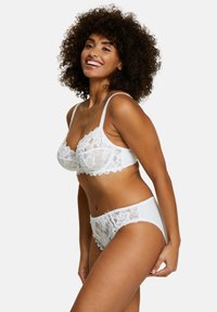 Ensemble de soutien-gorge et culotte en dentelle blanche avec des motifs floraux, des bords festonnés et des bretelles délicates, fabriqué en matériau doux et lisse.