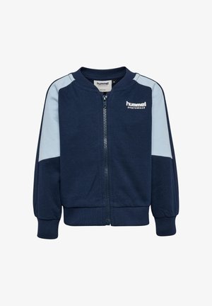 Granatowa kurtka na zamek z jasnoniebieskimi panelami, ściągaczami na mankietach i u dołu. Na górnej lewej stronie znajduje się biały znak "hummel". Miękki materiał.