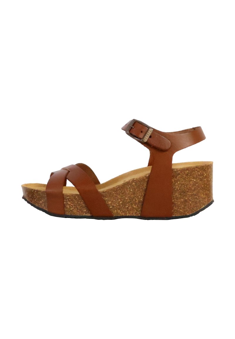 Sandalo wedge in pelle marrone con cinturini incrociati, una fibbia alla caviglia e una piattaforma in sughero. Suola in gomma testurizzata per una migliore aderenza.