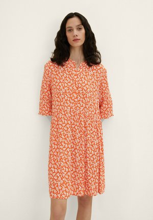 Robes fleuries orange à manches courtes, avec un décolleté boutonnière et une coupe ample. Le motif présente de petites fleurs blanches sur un tissu texturé.