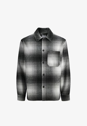 Chemise à carreaux noir et blanc en flanelle, dotée d'un devant boutonné, de manches longues, d'un col pointu et d'une poche poitrine.