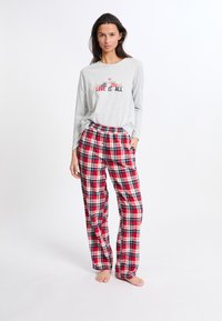 Hellgraues Langarmshirt mit dem Text "LOVE IS ALL". Rote und marineblaue Karo-Flanellhosen mit elastischem Bund und Seitentaschen.