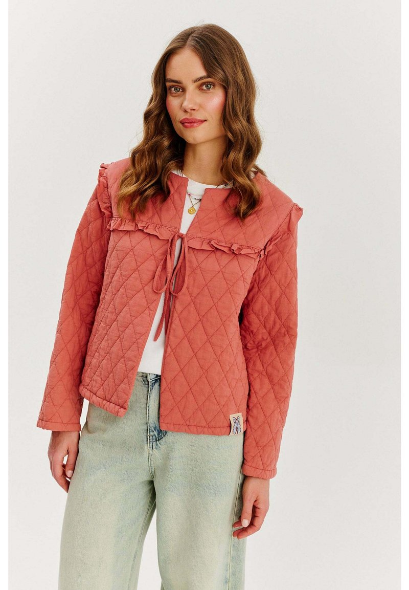 Kurtka pikowana w kolorze koralowo-czerwonym z falbaniastym kołnierzem i zapięciem na sznurek. Posiada długie rękawy oraz naszywkę z logo na dolnym wykończeniu.