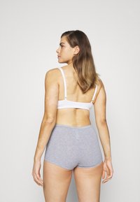 White cotton bra and light gray cotton briefs. The bra features adjustable straps; the briefs are fitted with a smooth waistband.