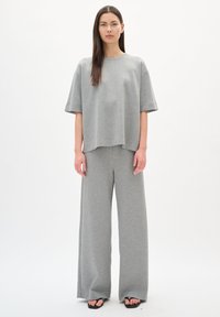 Grijze katoenen outfit met een losse, korte mouw top en wijde broek met een gladde textuur en minimalistisch ontwerp.