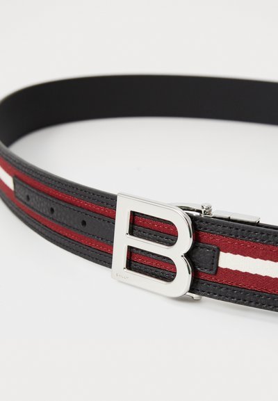 Svart lærbelte med røde og hvite striper, en metallisk sølvspenne med en "B"-design og flere justeringshull.