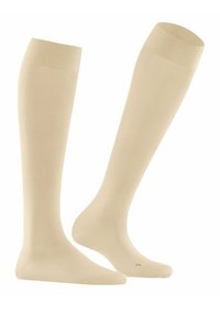 Beige kniehohe Socken aus glattem Stoff. Gerippter Bund, nahtlose Zehenpartie und ein leicht glänzendes Finish.